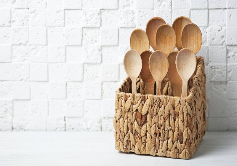 Wooden spoons in wicker basket on table against white wall | DIY Wooden Spoon