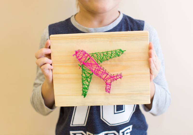 child holding string art plane | DIY Nail String Art | Easy Woodworking Projects For Kids