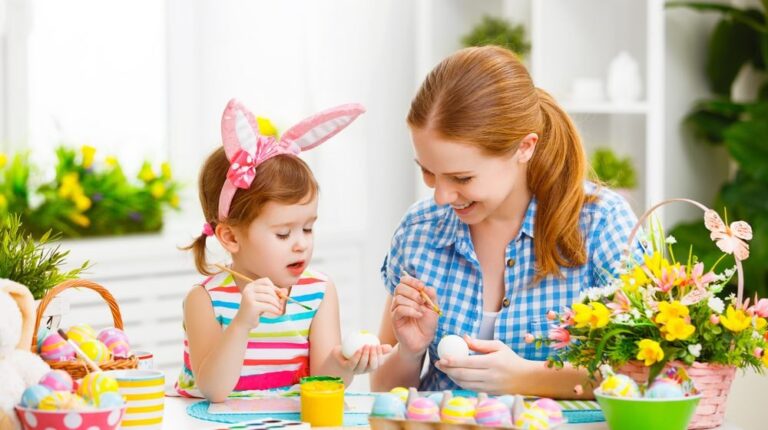 happy family mother and child girl paints eggs for Easter at home