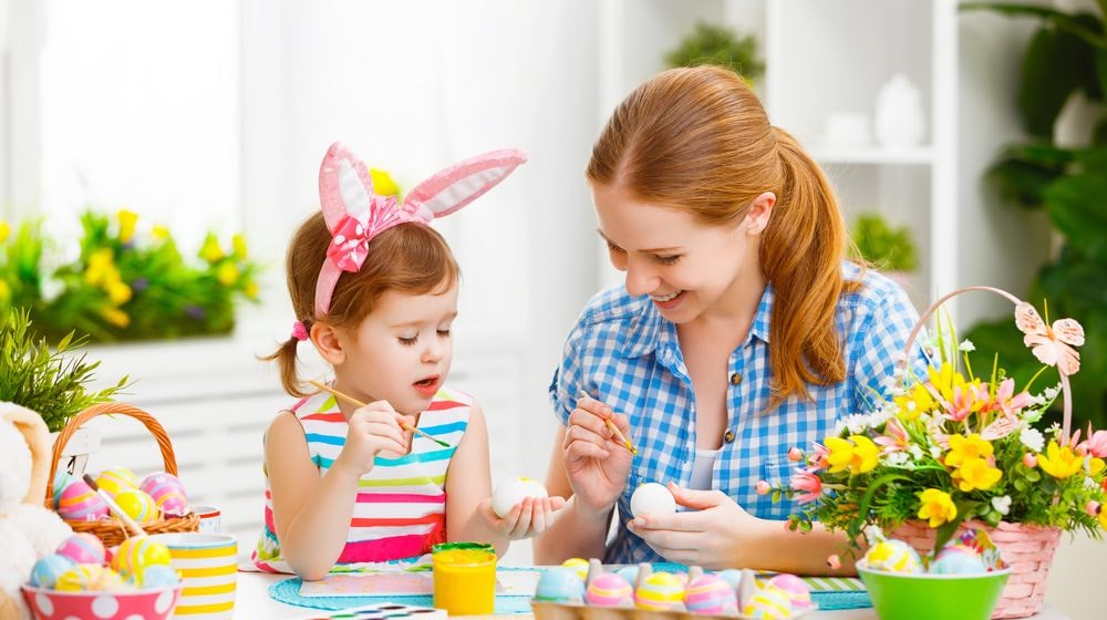 happy family mother and child girl paints eggs for Easter at home