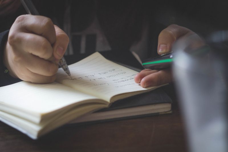 person writing notes | Homebrewery Guide: Everything You Need To Know Before Brewing Your First Beer 