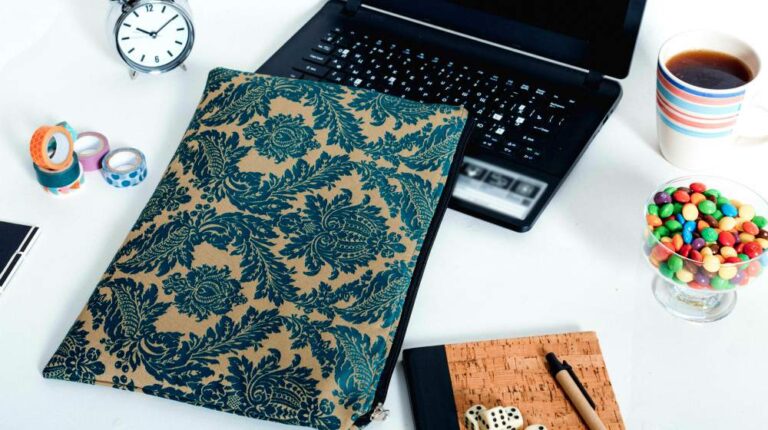 Black laptop on white desk with laptop case, candy, diary, clock | Laptop Case DIY Project You Can Do With Your Kids