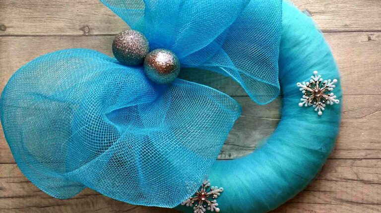 Blue christmas wreath with silver baubles and stars on wooden surface | Mesh Wreath Project: DIY Mesh Wreath Ideas For All Seasons | Featured