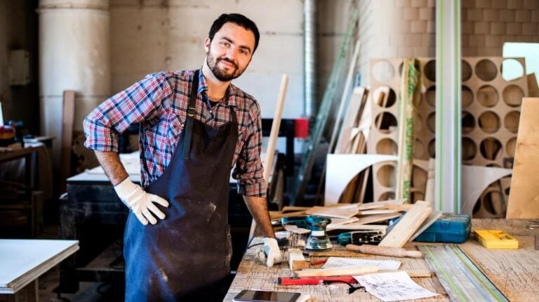 carpenter working carefully looking plans | DIY Folding Workbench Project For Your Garage To Save Space | featured