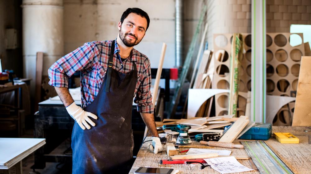 carpenter working carefully looking plans | DIY Folding Workbench Project For Your Garage To Save Space | featured