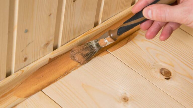 close-applying-dark-varnish-on-wooden | How To Paint Baseboards