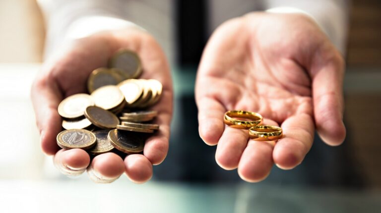 Close-up of a person's hand holding wedding rings and golden coins | How To Make Coin Rings | Featured