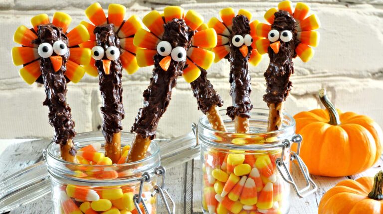 Cute thanksgiving turkey pretzel sticks with candy corn, still life against a white brick background | How To Make Choco Turkey Pretzels | Cute Thanksgiving Desserts | Featured