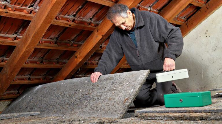 Feature | A man hiding valuables money at a hiding place in house | Sneaky Hacks For A Secret Place To Hide Your Valuables