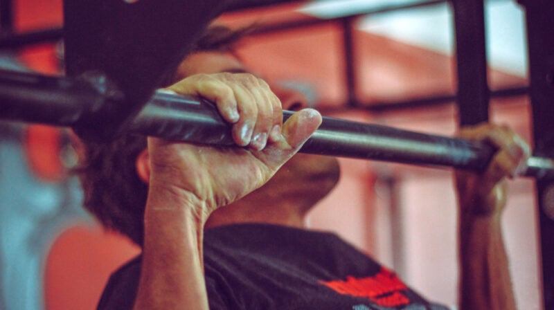 Man wearing black shirt doing pull ups | How To Make A Bombproof Pullup Bar | DIY Fitness | diy pullup bar | Featured