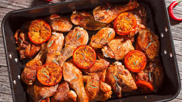 Tasty baked chicken with orange and rosemary in the baking dish on a table, New Year's Eve Recipes | New Year's Eve Dinner Recipes To Kick Off 2020 In Style | new year's eve appetizers | Featured