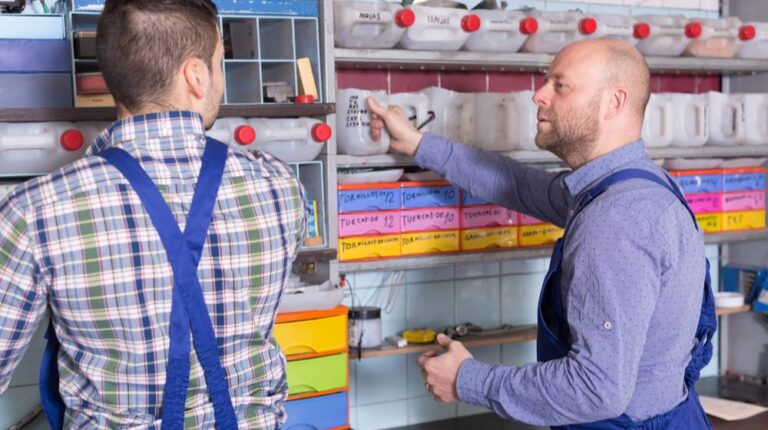 two-workmen-standing-near-storage-shelves | DIY Garage Storage Shelves To Maximize Your Space | featured
