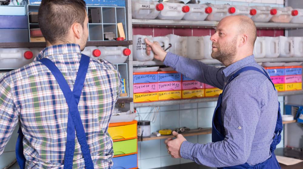 two-workmen-standing-near-storage-shelves | DIY Garage Storage Shelves To Maximize Your Space | featured