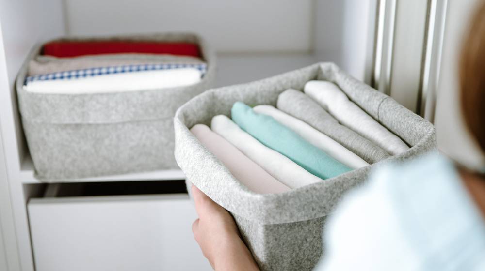 woman-organizing-clothes-wardrobe-putting-shirts | 17 Awesome Bedroom Organization Ideas You Can Do Before Holidays | Featured